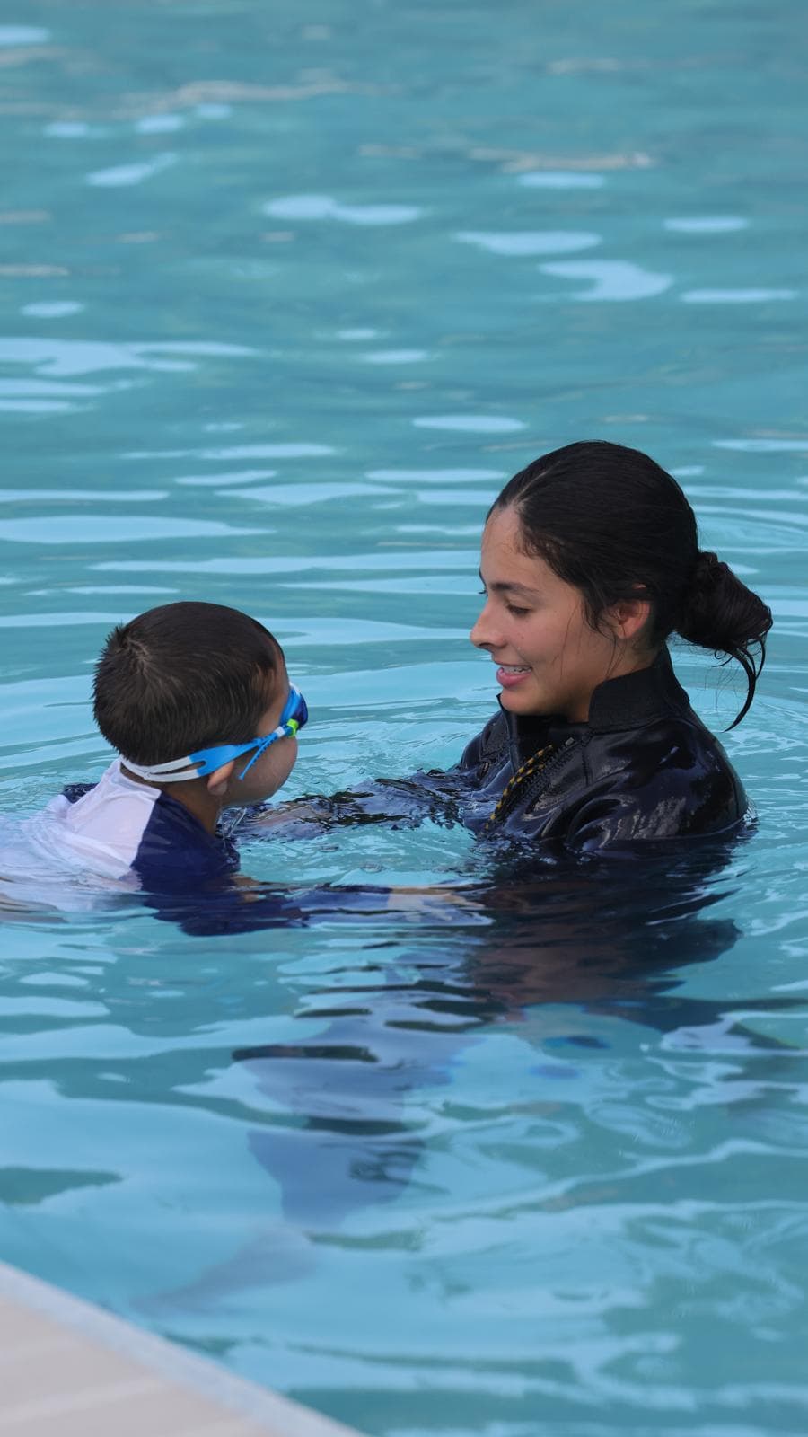 Juanita ensenando natacion a un nino